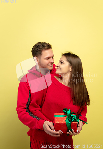 Image of Beautiful couple in love on yellow studio background. Valentine\'s Day, love and emotions concept