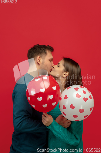 Image of Beautiful couple in love on red studio background. Valentine\'s Day, love and emotions concept