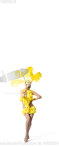 Image of Beautiful young woman in carnival, stylish masquerade costume with feathers dancing on white studio background.