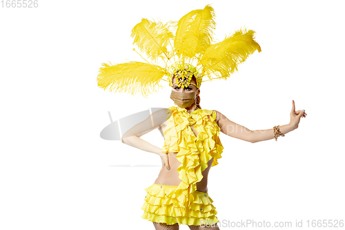 Image of Beautiful young woman in carnival, stylish masquerade costume with feathers dancing on white studio background.