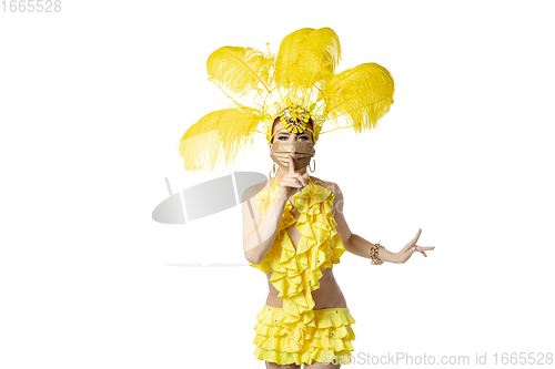 Image of Beautiful young woman in carnival, stylish masquerade costume with feathers dancing on white studio background.