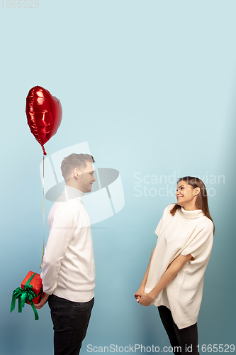 Image of Beautiful couple in love on blue studio background. Valentine\'s Day, love and emotions concept