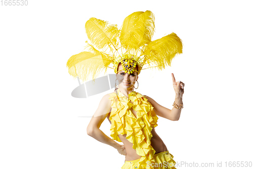 Image of Beautiful young woman in carnival, stylish masquerade costume with feathers dancing on white studio background.