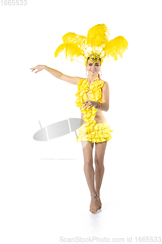 Image of Beautiful young woman in carnival, stylish masquerade costume with feathers dancing on white studio background.