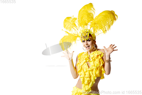 Image of Beautiful young woman in carnival, stylish masquerade costume with feathers dancing on white studio background.