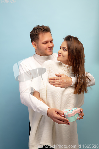 Image of Beautiful couple in love on blue studio background. Valentine\'s Day, love and emotions concept