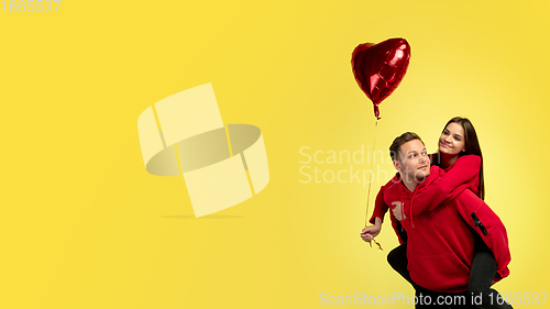 Image of Beautiful couple in love on yellow studio background. Valentine\'s Day, love and emotions concept