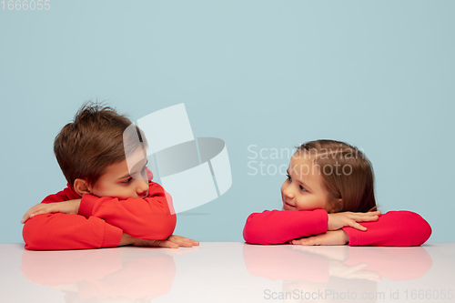 Image of Happy children isolated on blue studio background. Look happy, cheerful, sincere. Copyspace. Childhood, education, emotions concept