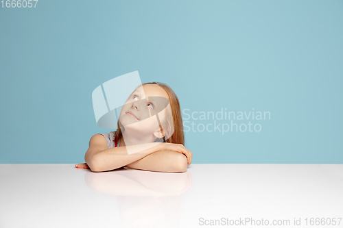 Image of Happy redhair girl isolated on blue studio background. Looks happy, cheerful, sincere. Copyspace. Childhood, education, emotions concept