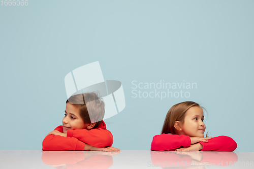 Image of Happy children isolated on blue studio background. Look happy, cheerful, sincere. Copyspace. Childhood, education, emotions concept