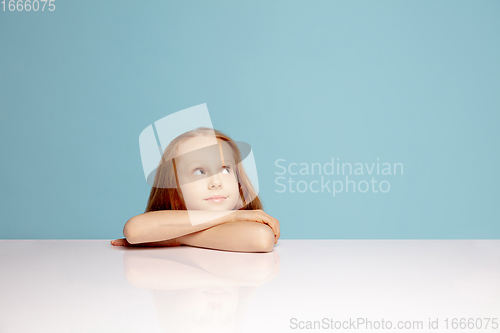 Image of Happy redhair girl isolated on blue studio background. Looks happy, cheerful, sincere. Copyspace. Childhood, education, emotions concept