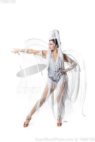 Image of Beautiful young woman in carnival, stylish masquerade costume with feathers dancing on white studio background. Concept of holidays celebration, festive time, fashion