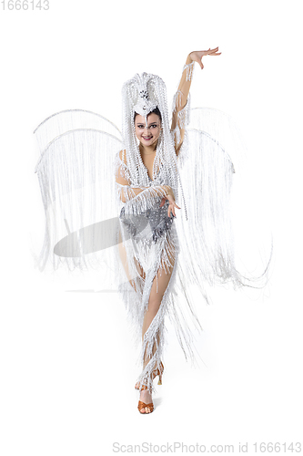 Image of Beautiful young woman in carnival, stylish masquerade costume with feathers dancing on white studio background. Concept of holidays celebration, festive time, fashion