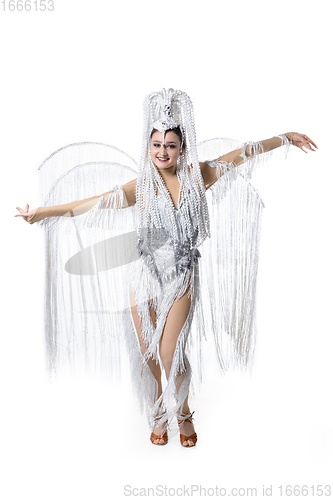 Image of Beautiful young woman in carnival, stylish masquerade costume with feathers dancing on white studio background. Concept of holidays celebration, festive time, fashion