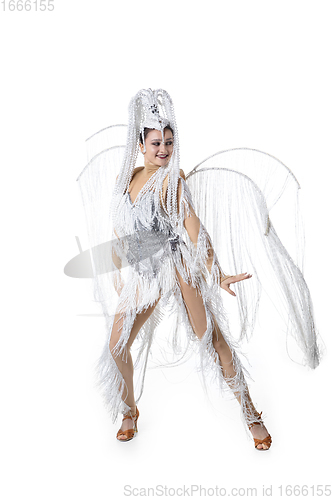 Image of Beautiful young woman in carnival, stylish masquerade costume with feathers dancing on white studio background. Concept of holidays celebration, festive time, fashion