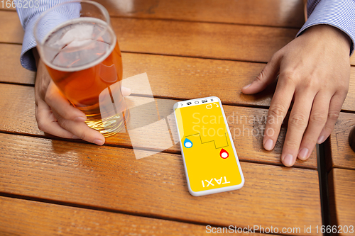 Image of Close up hands holding smartphone with online taxi service on the screen. Staying safe during lockdown. Modern tech and healthcare