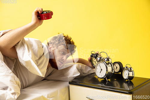 Image of Man wakes up and he\'s mad at clock ringing, switches it off by breaking down