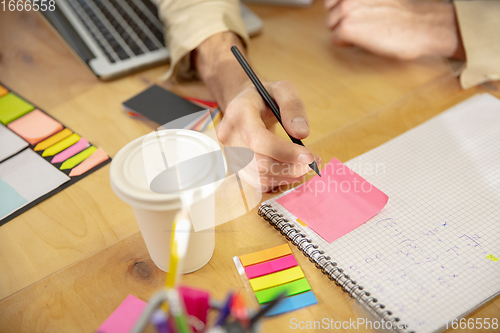 Image of Hands of colleagues working together in a office using modern devices and gadgets during creative meeting. Close up.