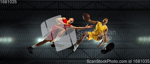 Image of Young basketball players in competitive fight, motion in flight on black background, look from the bottom. Concept of sport, movement, energy and dynamic.