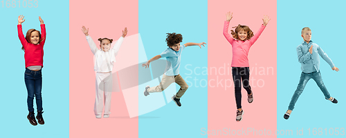 Image of Group of elementary school kids or pupils jumping in colorful casual clothes on bicolored studio background. Creative collage.