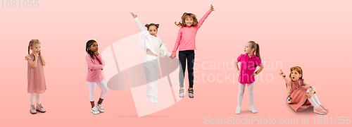 Image of Group of elementary school kids or pupils jumping in colorful casual clothes on pink studio background. Creative collage.