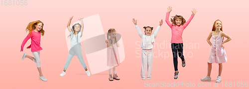 Image of Group of elementary school kids or pupils jumping in colorful casual clothes on pink studio background. Creative collage.