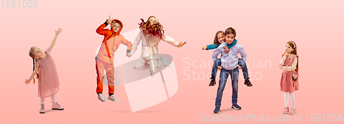 Image of Group of elementary school kids or pupils jumping in colorful casual clothes on pink studio background. Creative collage.