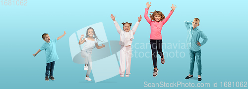 Image of Group of elementary school kids or pupils jumping in colorful casual clothes on blue studio background. Creative collage.