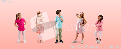 Image of Group of elementary school kids or pupils in colorful casual clothes on pink studio background. Creative collage.