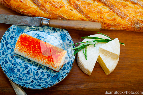 Image of French cheese and fresh  baguette on a wood cutter