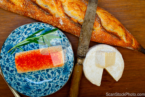 Image of French cheese and fresh  baguette on a wood cutter