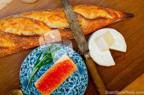 Image of French cheese and fresh  baguette on a wood cutter