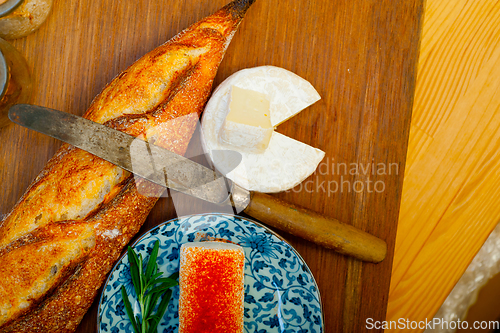 Image of French cheese and fresh  baguette on a wood cutter