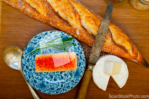 Image of French cheese and fresh  baguette on a wood cutter