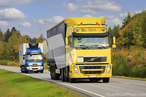 Image of Yellow and Blue Volvo Trucks on the Road