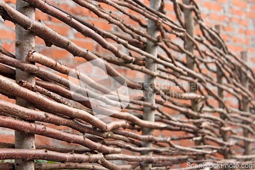 Image of Wooden stylized horizontal fence and red brick wall as a defocus