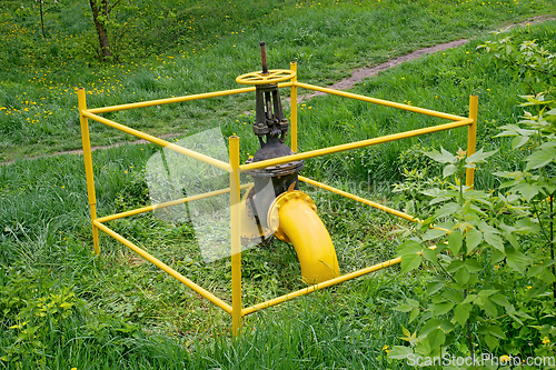 Image of Gas valve outside among green grass