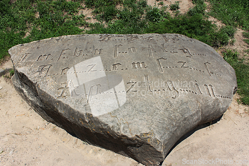 Image of Encoded ancient engraved inscription by Gothic font with missing