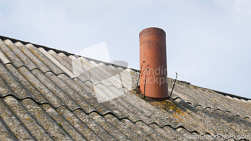 Image of Chimney in the form of a pipe on the old slate roof of the barn,