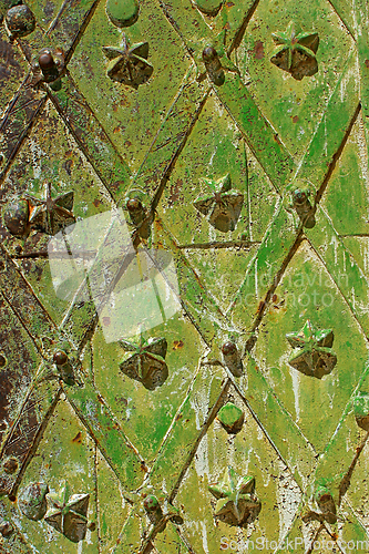 Image of Old metal door with decorative figures painted mainly in green