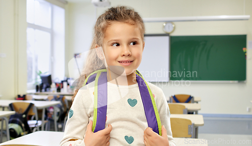 Image of happy little girl with backpack at school