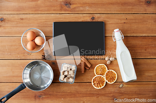 Image of tablet pc, ingredients for eggnog cooking