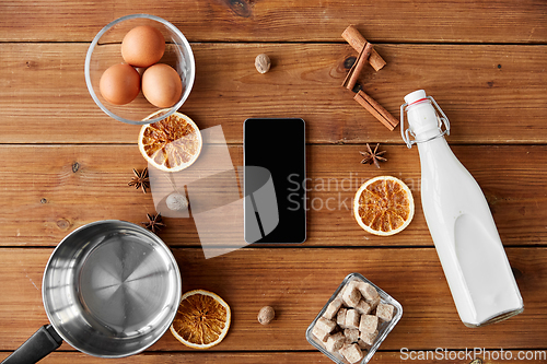 Image of smartphone, ingredients for eggnog cooking