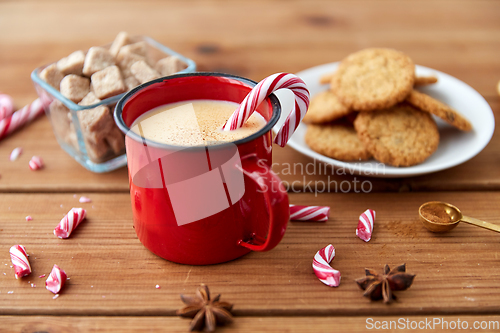 Image of cup of eggnog with candy cane, cookies and anise