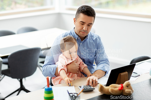 Image of father with baby working at home