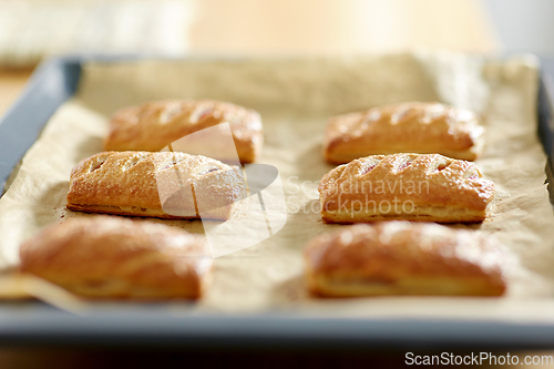 Image of close up of baking tray with jam pies