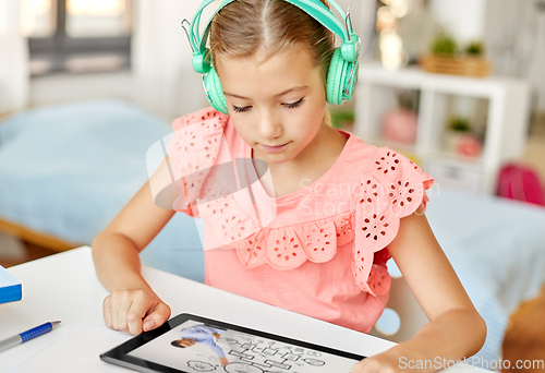 Image of girl in headphones with tablet computer at home