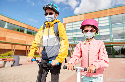 Image of children in masks riding scooters over school