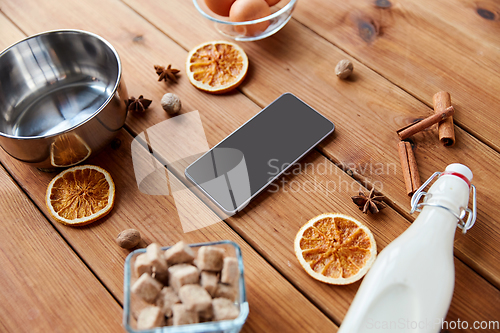 Image of smartphone, ingredients for eggnog cooking