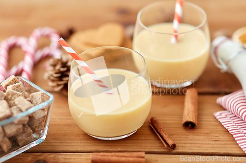 Image of glasses of eggnog, ingredients and spices on wood